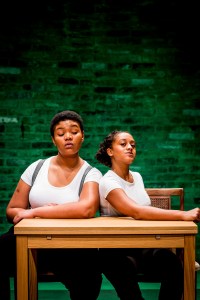 Kudzanayi and Ayesha sit back to back.