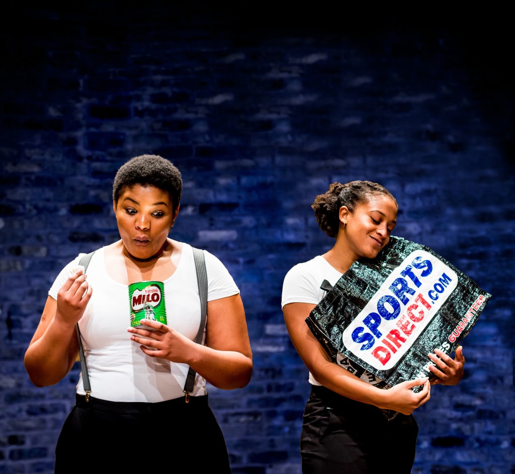 Two women, one eating out of a Milo tin and one holding a Sports Direct bag